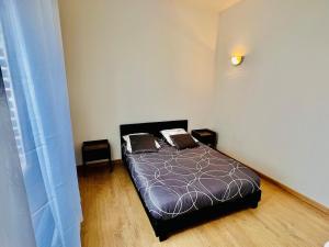 a bedroom with a bed with two pillows on it at Cozy & Lumineux in Marly