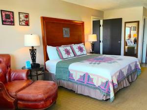 a bedroom with a large bed and a chair at The Lodge at Russell - Russell Inn in Russell +36 photos