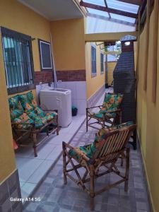 a patio with two chairs and a bath tub at Casinha marazul in Itanhaém