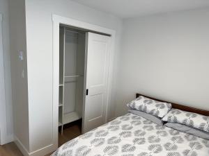 a bedroom with a bed and a closet at Modern Townhouse Room in Fredericton