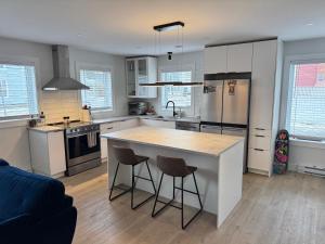 a kitchen with a large island with two bar stools at Modern Townhouse Room in Fredericton