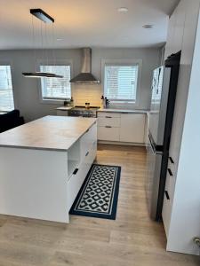 a kitchen with a white counter and a refrigerator at Modern Townhouse Room in Fredericton +1 photo