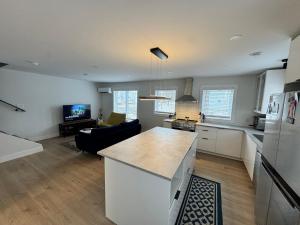 a kitchen and a living room with a counter top at Modern Townhouse Room in Fredericton