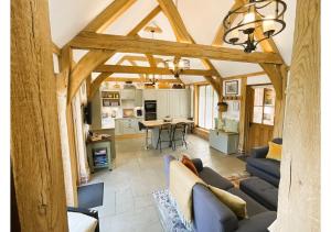 a living room with a couch and a table at The Saddlery Barn Retreat in Ashford