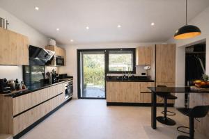 a kitchen with wooden cabinets and a table with chairs at Mougins Centre - Bastide pierre rénovée spa et piscine privé in Mougins