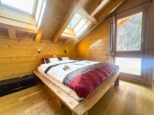 a bedroom with a bed in a wooden cabin at Chalet Boder - Vue MontBlanc - Cheminée in Finhaut