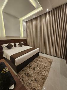 a bedroom with a large bed and a rug at أجنحة توليب للشقق المخدومة in Hafr Al-Batin