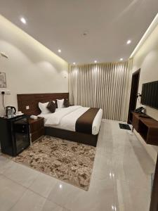 a hotel room with a bed and a television at أجنحة توليب للشقق المخدومة in Hafr Al-Batin