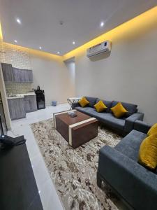 a living room with a couch and a coffee table at أجنحة توليب للشقق المخدومة in Hafr Al-Batin