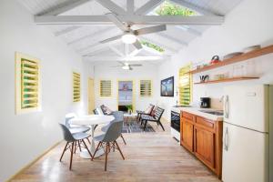 a kitchen with a white refrigerator and a table and chairs at Puerta Azul in Sandy Bay +55 photos