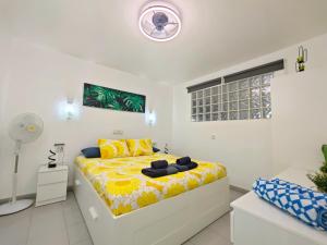 a bedroom with a bed with a yellow bedspread at El Pisito Dulce Vista in Tías