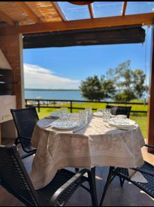 a dining table with chairs and a view of the ocean at Riviera Barão de Antonina - Chalés na Represa - Piscina vista incrível in Barão de Antonina