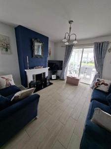 a living room with a couch and a fireplace at Notre Petit Chateau in Rosslare Harbour