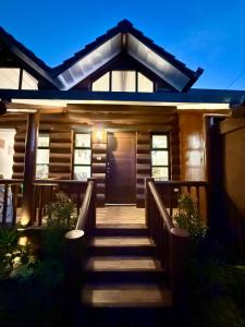 a house with a wooden staircase leading to a door at Log Cabin Tagaytay in Tagaytay +4 photos