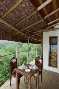 a table and chairs on a porch with a view at Villa Girassol in Ilhabela