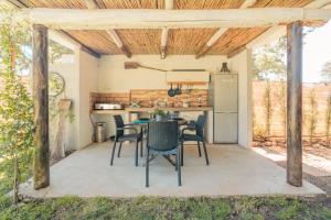 an outdoor kitchen with a table and chairs on a patio at Cabaña Rural El Arbol near Setenil - Ronda con piscina in Ronda