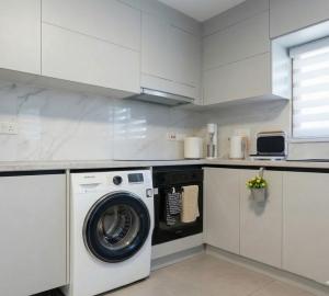 a white kitchen with a washing machine in it at TelMar Kiti Escape House in Kiti