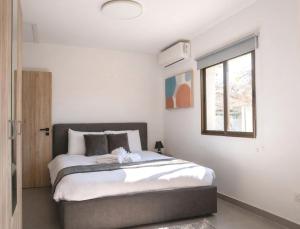 a bedroom with a bed and a window at TelMar Kiti Escape House in Kiti
