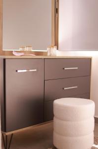a bathroom with a vanity with a mirror and a stool at TelMar Kiti Escape House in Kiti +36 photos