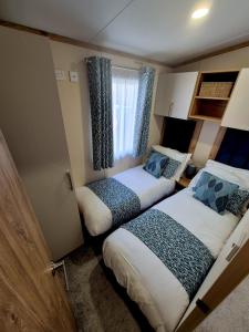 a small room with two beds and a window at Whitstable Hemsworth Villa in Seasalter