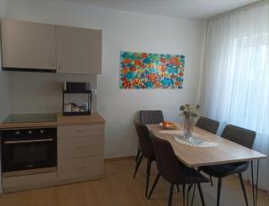 a kitchen with a table with chairs and a painting on the wall at Casa Mia 2 in Punat