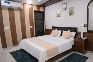 a bedroom with a bed with white sheets and pillows at Hotel In Kashi in Varanasi