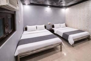 two beds in a small room with two at Hotel In Kashi in Varanasi