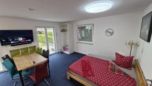 a room with a bed and a desk and a table at Ferienwohnungen Im Grund 22, 22a, 22c Birkenstein in Hoppegarten