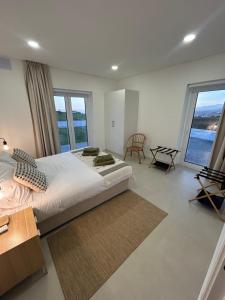 a bedroom with a large bed and large windows at Azorescape in Lagoa