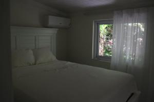 a bedroom with a white bed and a window at Heaven Can Wait APT2 in Steer Town