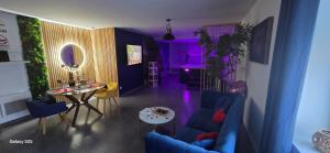 a living room with a blue couch and a table at L'escale du désir, Spa privatif in Calais