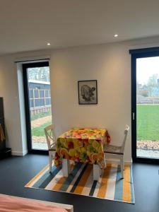 a room with a table and a chair and windows at Het Hunebedje in Vries