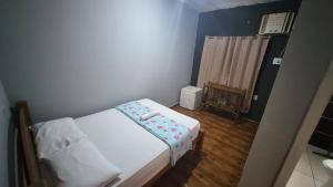 a small bedroom with a white bed in a room at Pousada Cactos in Chapada dos Guimarães