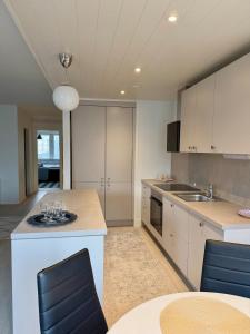 a kitchen with white cabinets and a table with chairs at Apartment Kopin5 in Kokkola