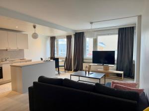 a living room with a couch and a table and a kitchen at Apartment Kopin5 in Kokkola