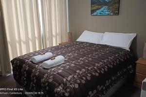a bedroom with a bed with two towels on it at Mt Hutt Views at 23 Methven in Methven