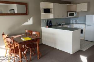 a kitchen with a counter and a table with chairs at Mt Hutt Views at 23 Methven in Methven