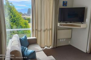 a living room with a couch and a large window at Mt Hutt Views at 23 Methven in Methven