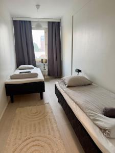 a bedroom with two beds and a window at Apartment Kopin5 in Kokkola