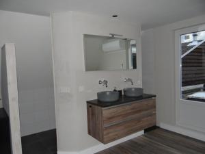 a bathroom with two sinks and a mirror at Torenzicht in Kapelle