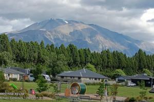 a snow capped mountain in the distance with houses and trees at Mt Hutt Views at 23 Methven in Methven