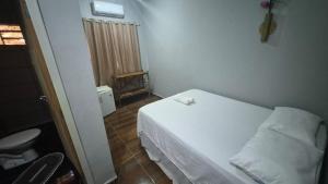 a small bedroom with a white bed in a room at Pousada Cactos in Chapada dos Guimarães +3 photos