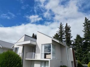 a white house with trees in the background at Opuke Crash Pad Methven - with mountain views. in Methven