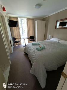 a bedroom with a large bed with two towels on it at Opuke Studio Methven in Methven