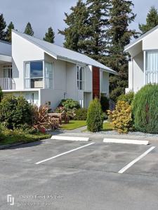 a white house with a parking lot in front of it at Opuke Studio Methven in Methven