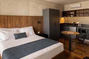 a bedroom with a bed and a table and a kitchen at Lapso At Asís in Guadalajara