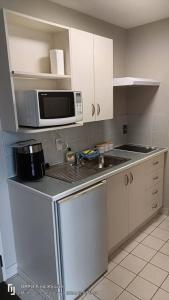 a small kitchen with a microwave and a sink at Mt Hutt Studio at 23 Methven in Methven