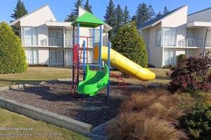 a playground with a slide in front of a building at Mt Hutt Studio at 23 Methven in Methven
