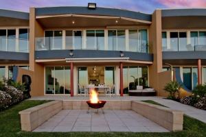 a house with a fire pit in front of it at Oceanfront Oasis in Grange