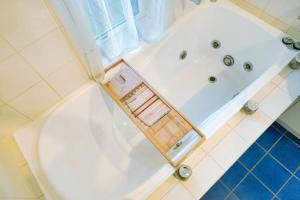 a bathroom with a tub with a chair in it at Oceanfront Oasis in Grange +45 photos